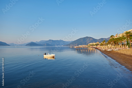 mountain and lonely motor boat reflected sunrise in a calm sea, Marmaris