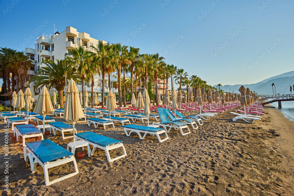 Deserted beach in the morning sun. The beach at dawn. Empty sunbeds. Beach without people. Marmaris