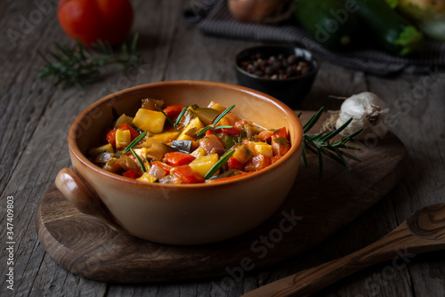 Chopped cooked vegetables on dark wood. Traditional ratatouille with zucchini, bell pepper and eggplant