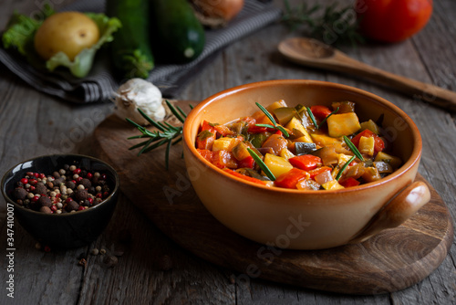 Chopped cooked vegetables on dark wood. Traditional ratatouille with zucchini, bell pepper and eggplant