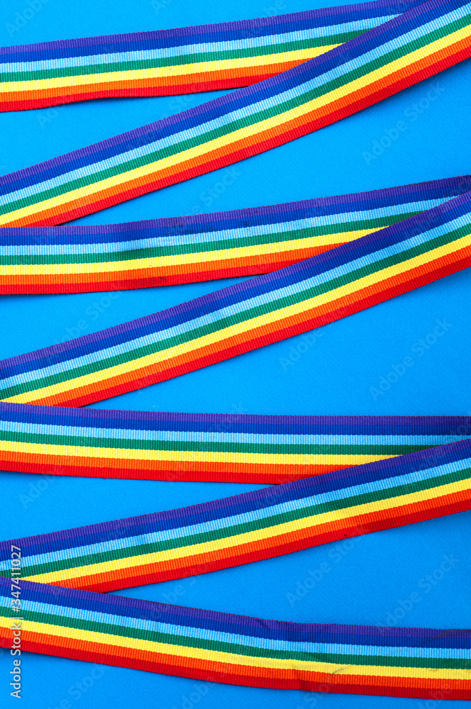 crossed rainbow ribbons and awareness ribbon on a blue background crossed rainbow ribbons and awareness ribbon on a blue background