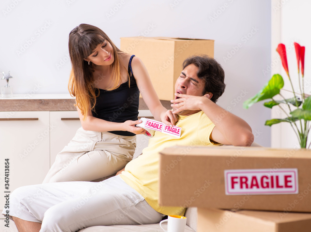 Young couple moving to new flat with fragile things Young couple moving to new flat with fragile things