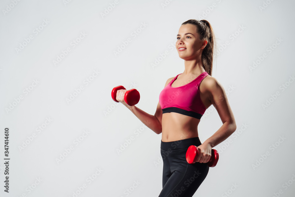 Girl Exercising with Dumbbells Standing Front To Camera Over Gray Background Girl Exercising with Dumbbells Standing Front To Camera Over Gray Background