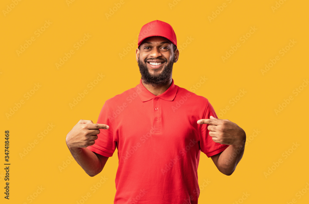 Delivery Man Pointing Fingers At Himself Posing On Yellow Background Delivery Man Pointing Fingers At Himself Posing On Yellow Background