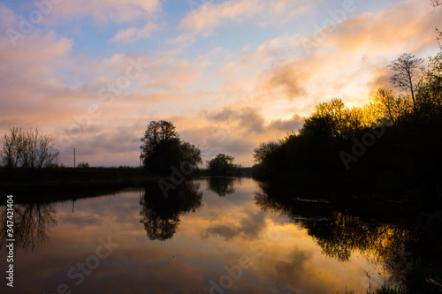 Beautiful sunrise on the river. Landscape of wild nature with river and orange sky