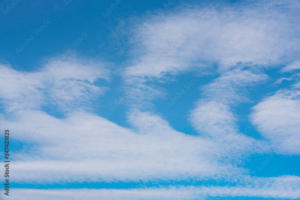 white clouds in sickle shapes on blue sky