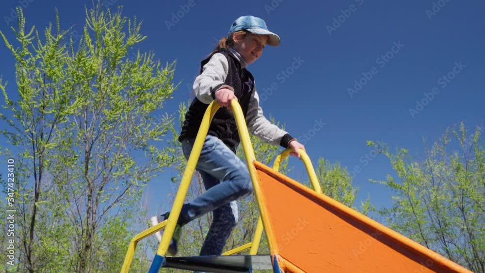 Children playing and sliding on the playground next to a condominium ...