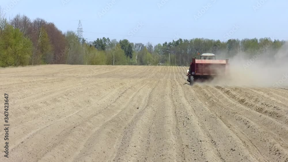 A tractor and farm implements planting potatoes in the fertile farm fields. A pile of potatoes on a trailer with vintage tractor.
A tractor and farm implements planting potatoes in the fertile farm fields. A pile of potatoes on a trailer with vintage tractor.