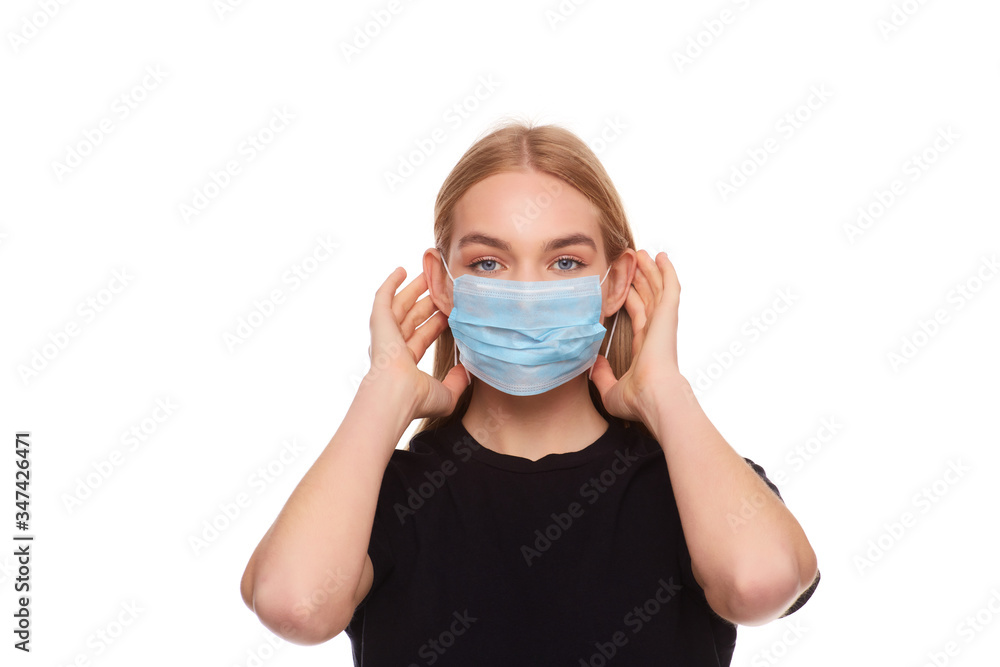 Girl puts a medical face mask for protection against infection. Girl puts a medical face mask for protection against infection.