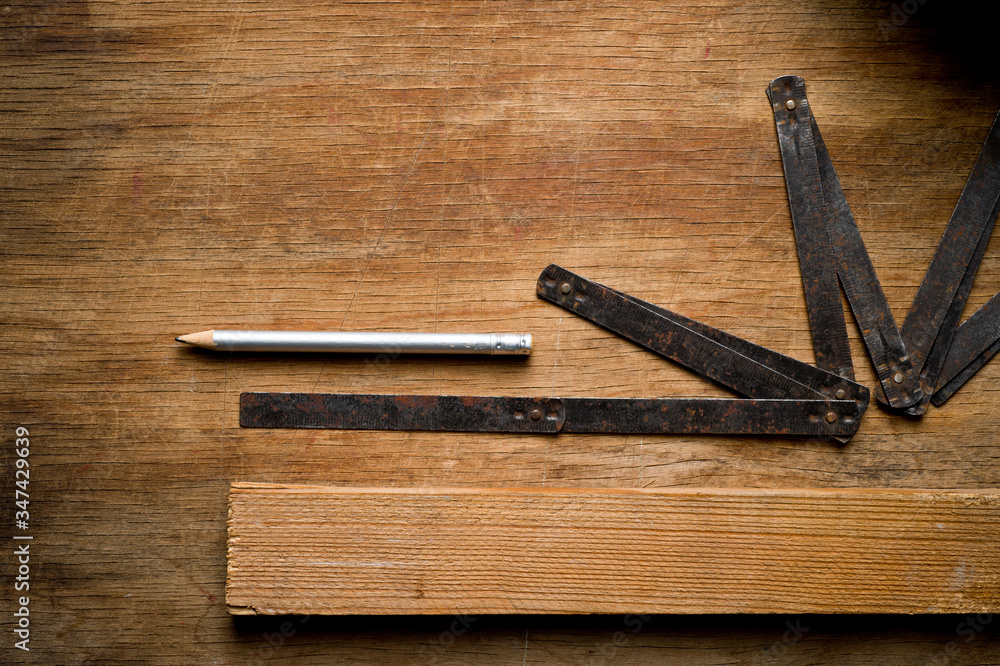 Measuring iron folding meter old, photographed on a shabby wooden surface. Measuring iron folding meter old, photographed on a shabby wooden surface.