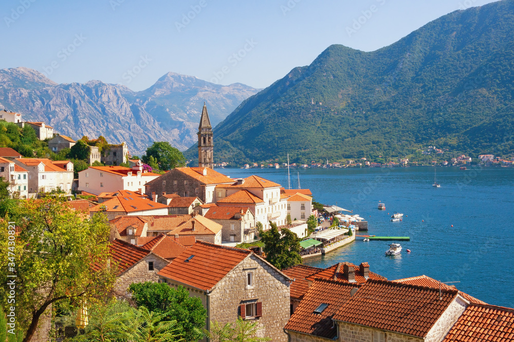 Beautiful Mediterranean landscape on sunny autumn day. Ancient town of Perast with bell tower of St. Nicholas Church. Montenegro, Adriatic Sea, Bay of Kotor