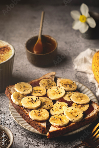 Sandwich with caramel, banana and chia seeds. Delicious breakfast concept with coffee.