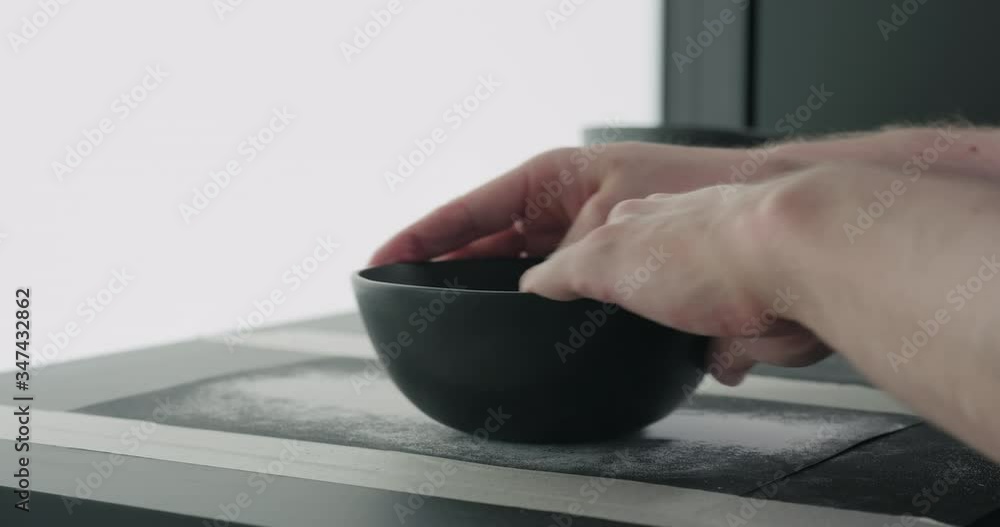 Slow motion man hands sanding bottom of black ceramic bowl Slow motion man hands sanding bottom of black ceramic bowl