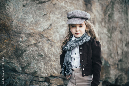 girl stands on the edge of a cliff near a large stone in a jacket © rss_maxim