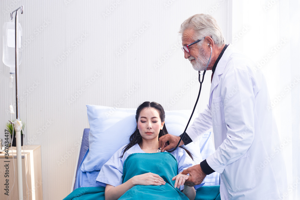 Fototapeta premium man doctor using stethoscope health check for women patients in hospital.