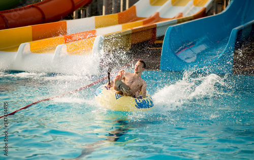 Happy person has active summer vacation activities at the water park.