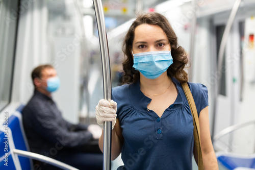 Woman in disposable mask in subway train