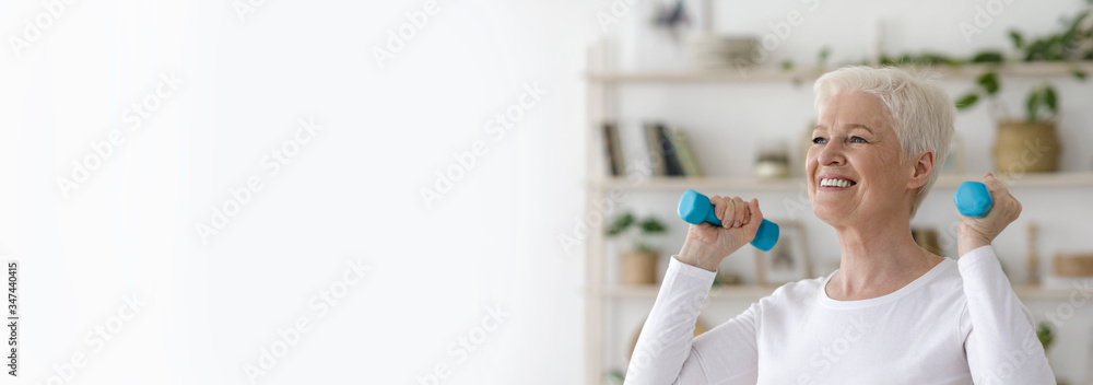 Active Retirement. Sporty senior woman exercising with dumbbells at home Active Retirement. Sporty senior woman exercising with dumbbells at home