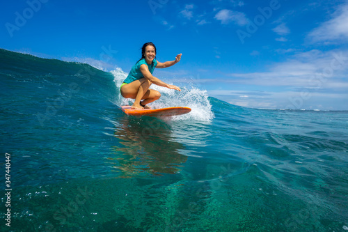 beautiful girl surfing on big transparent waves