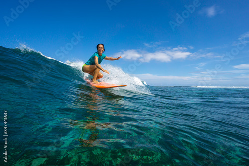 Canvas Print beautiful girl surfing on big transparent waves