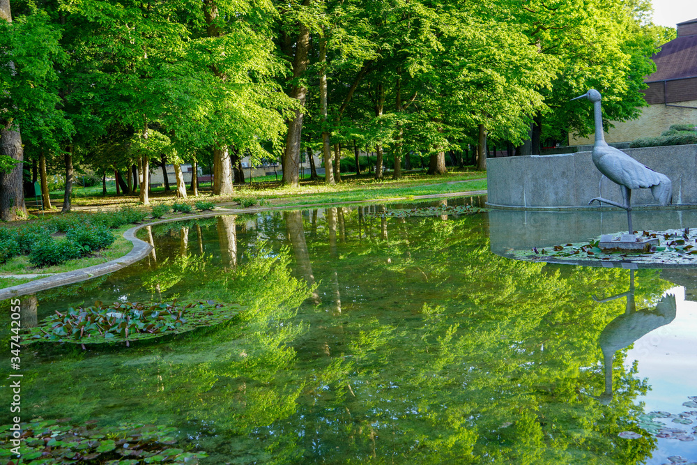 Fototapeta premium A lake with a forest of spring-colored trees reflected in the water 