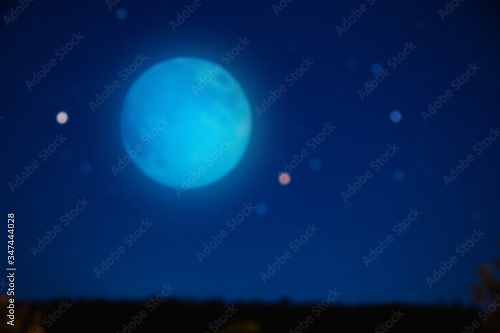 Full blue Moon on a starry skies. De-focused photo.