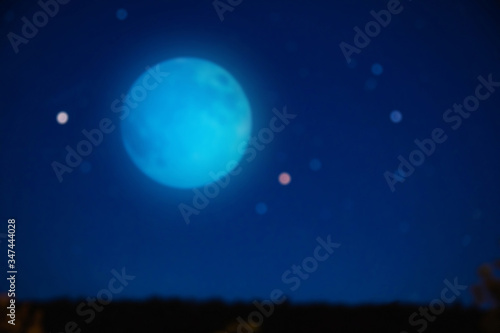 Full blue Moon on a starry skies. De-focused photo.