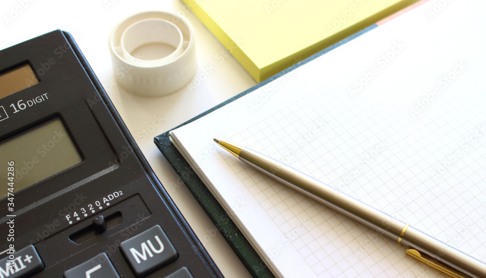Calculator pen and notebook on white background Calculator pen and notebook on white background