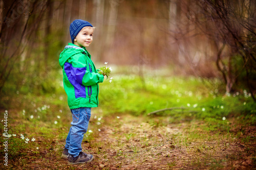 boy child walks in the forest in spring, snowdrops, first flowers, April, nature © Елена Бурова
