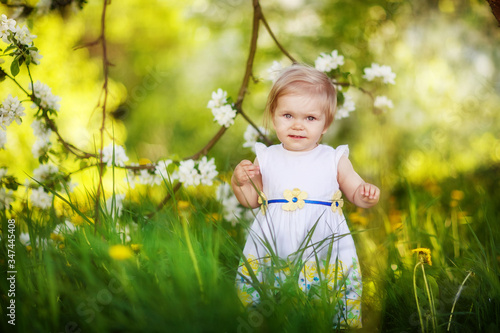 девочка ребенок гуляет весной в саду, яблоня цветет, цветение, май 