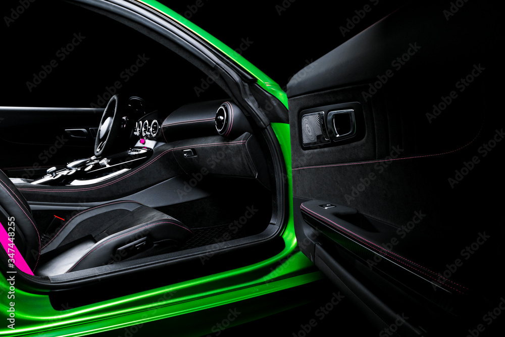 Modern Luxury sport car inside. Interior of prestige car. Black Leather seats with pink stitching. Black perforated leather. Modern car interior details.