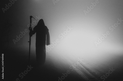 Fotografie Death grim Reaper skeleton wearing a black robe and wielding a scythe, Memento M