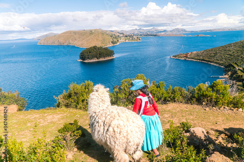 Tableau sur toile Girl and Llama Alpaca with Island on Isla del Sol in Bolivia background