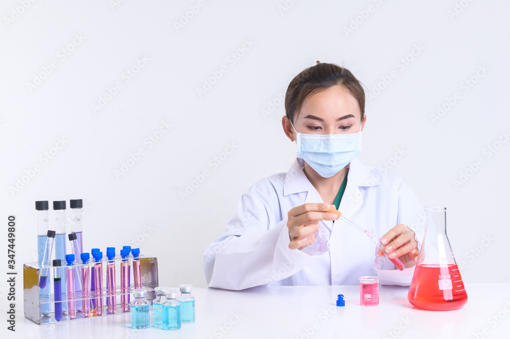 Female laboratory assistant with chemical experiment in scientific laboratory Female laboratory assistant with chemical experiment in scientific laboratory