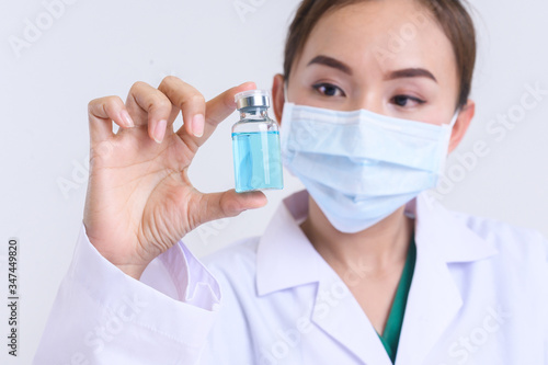 Female laboratory assistant with chemical experiment in scientific laboratory