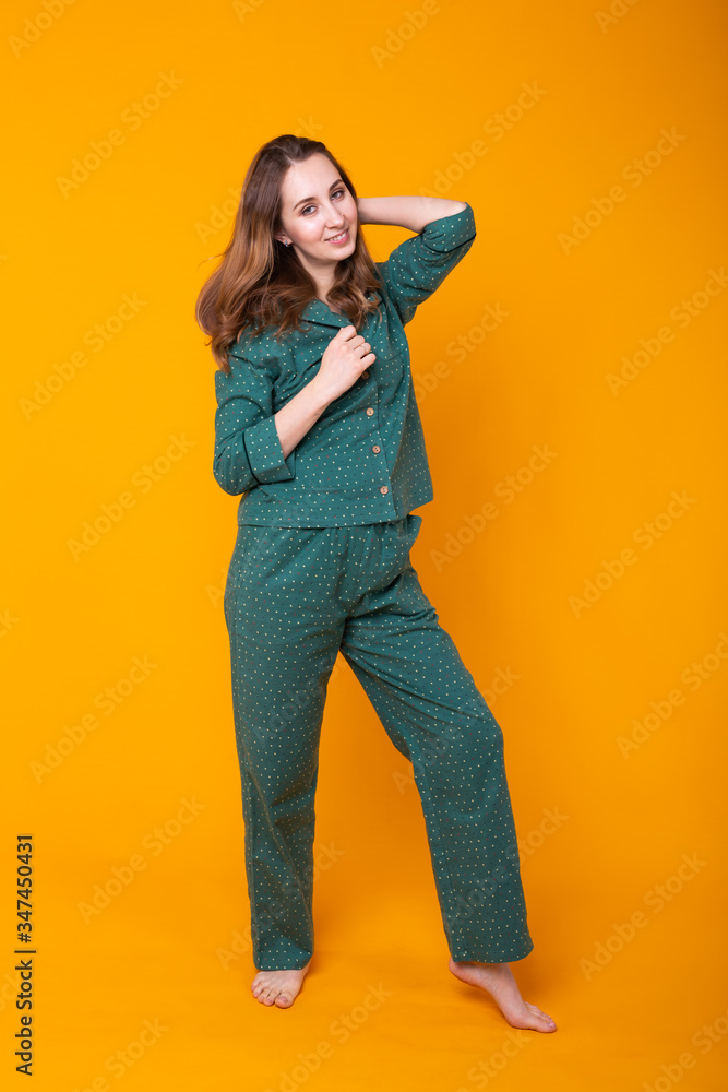Young girl posing in pajamas on yellow background. Relax good mood, lifestyle and sleepwear concept. Young girl posing in pajamas on yellow background. Relax good mood, lifestyle and sleepwear concept.