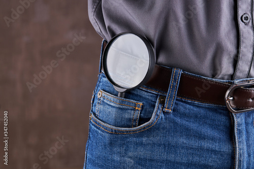 search and discovery concept. magnifier glass at front jeans pocket.