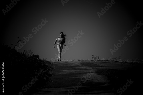 Frau mit langen Haaren auf einer Strasse mit low key technik