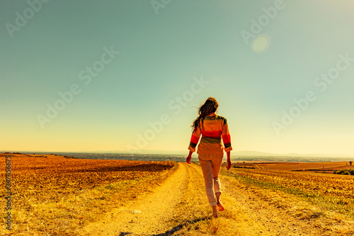 Frau beim Spaziergang auf einem Feldweg