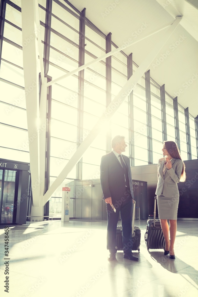 Fototapeta premium Portrait of business people walking while talking in airport
