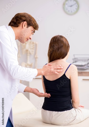 Female patient visiting young handsome doctor chiropractor