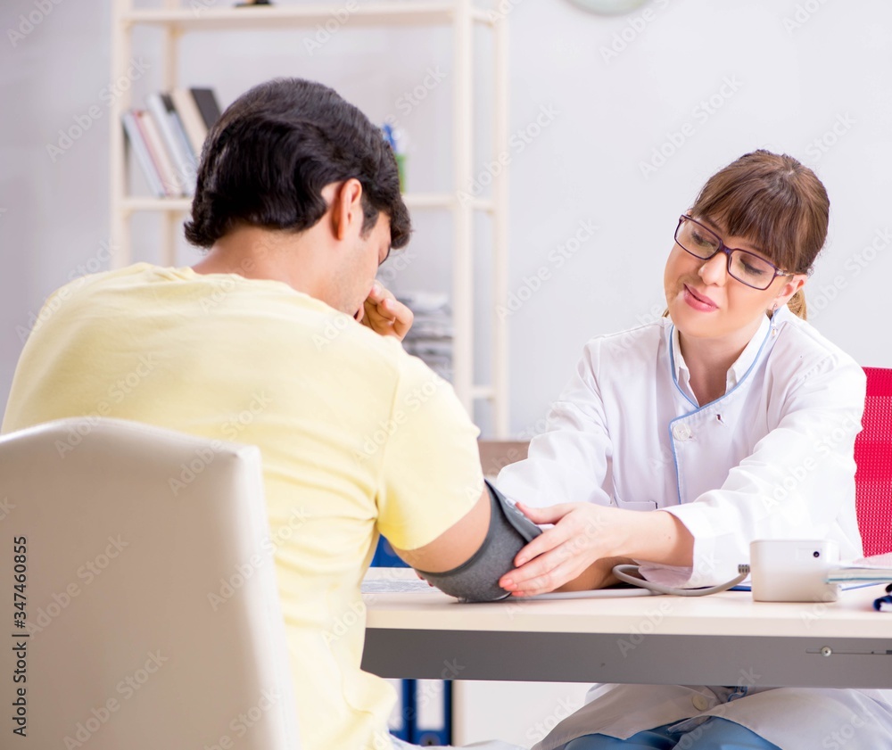 Young doctor checking patients blood pressure Young doctor checking patients blood pressure