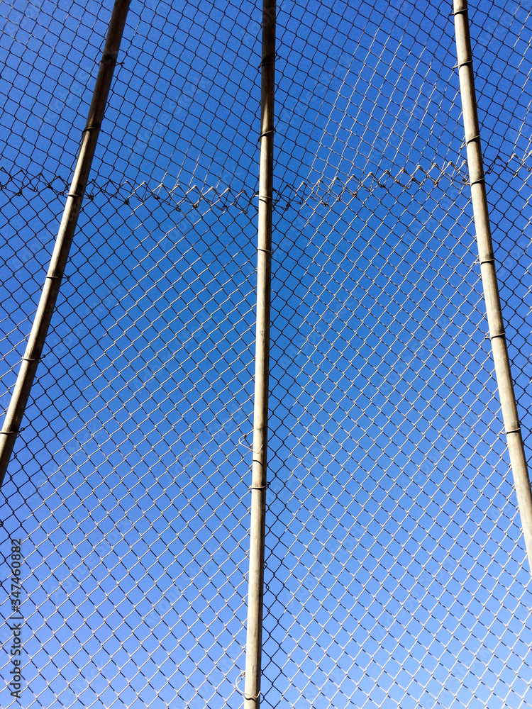 Geometric design element chain link baseball backstop fence and blue