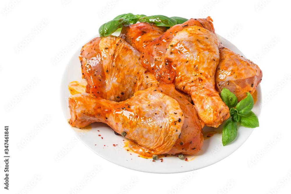 Raw chicken marinated drumstick or legs in a plate with herbs and spices isolated on white background Raw chicken marinated drumstick or legs in a plate with herbs and spices isolated on white background