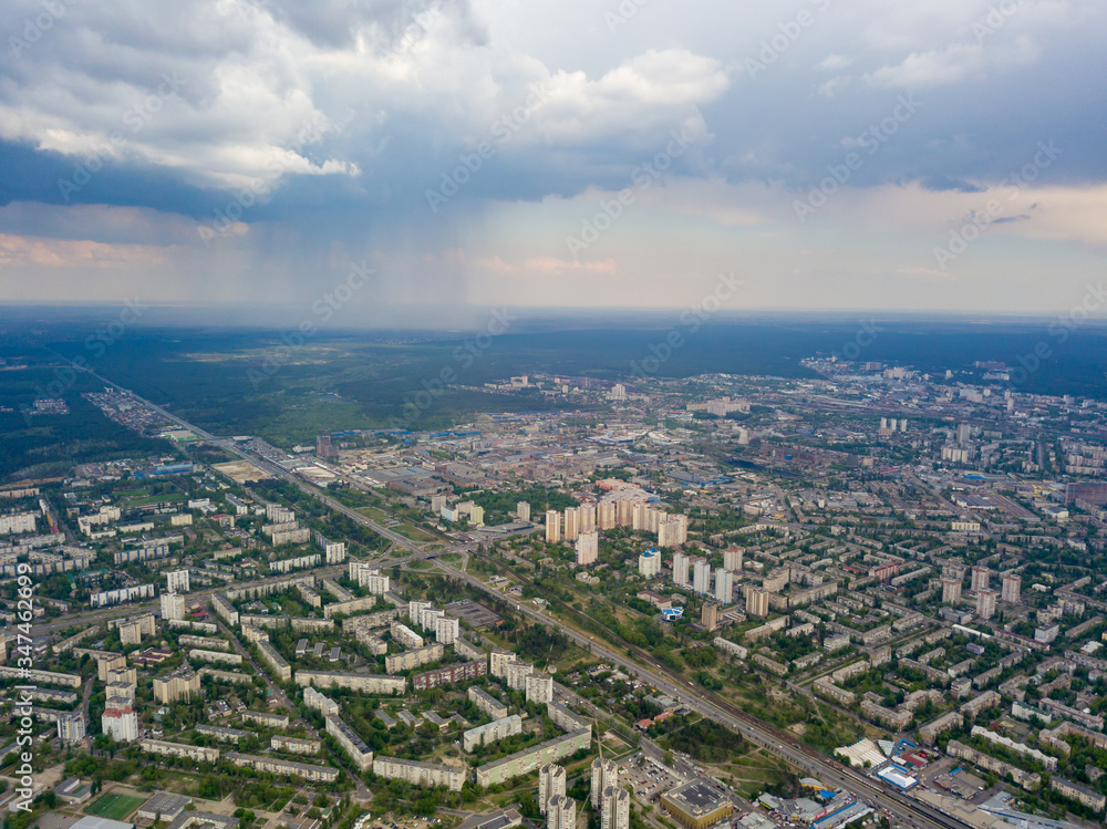 Obraz premium Spring rain over Kiev. There are black thunderclouds in the sky, rain is falling on the city. Aerial drone view.