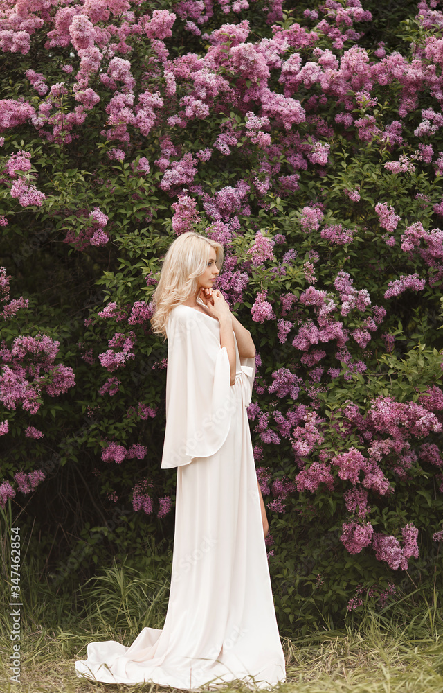 Beautiful adult woman in a flowering lilac