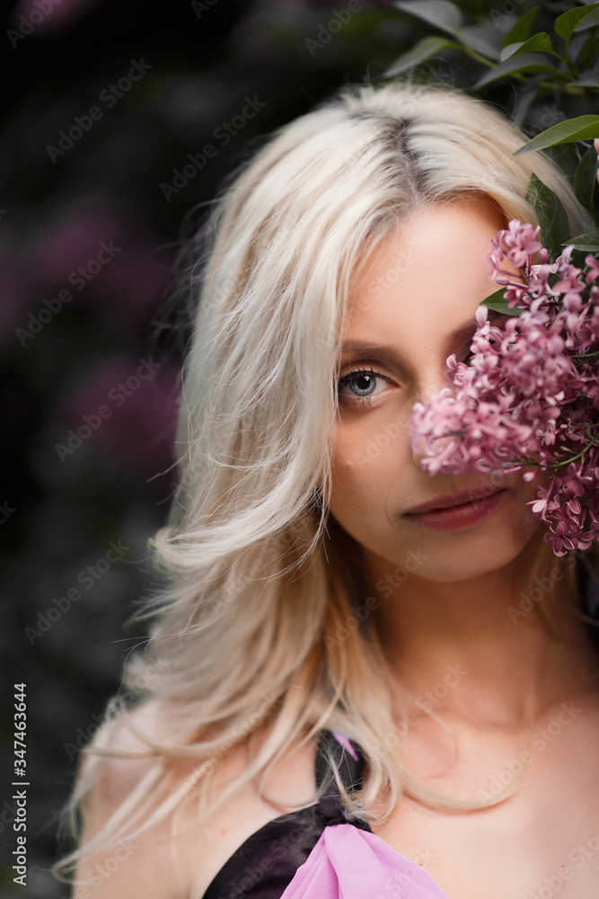 Beautiful adult woman in a flowering lilac Beautiful adult woman in a flowering lilac