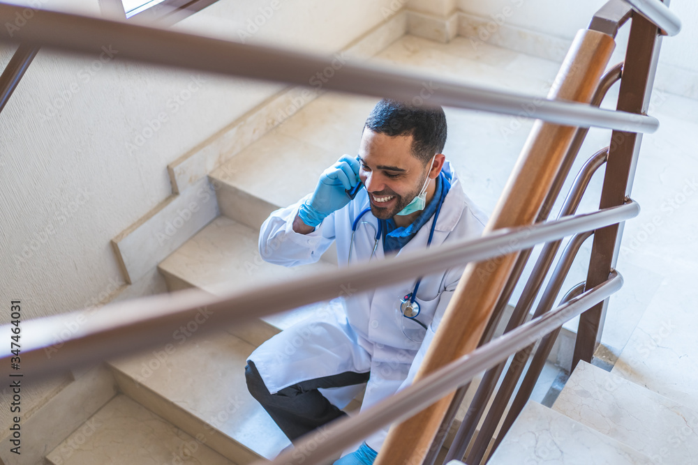 Doctor Talking by Phone at Hospital Stairs on His Work Brake . Doctor Talking by Phone at Hospital Stairs on His Work Brake .