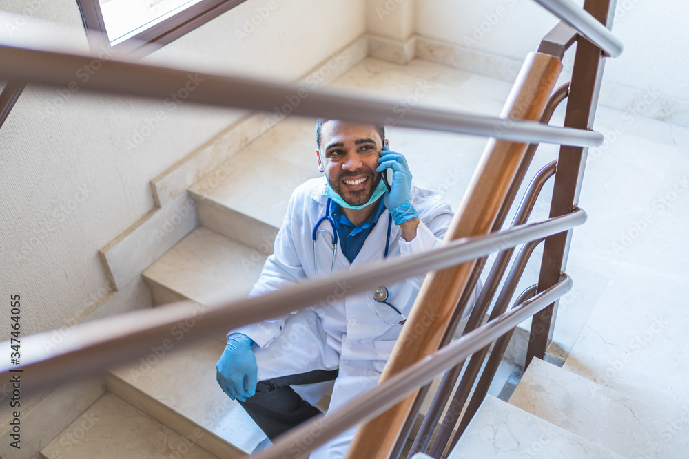 Doctor Talking by Phone at Hospital Stairs on His Work Brake . Doctor Talking by Phone at Hospital Stairs on His Work Brake .