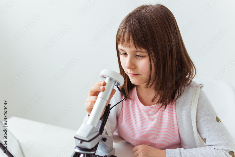 Child girl in science class using digital microscope. Technologies, children and learning concept. Child girl in science class using digital microscope. Technologies, children and learning concept.